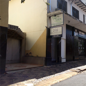 A placa preta e branca traz o símbolo da justiça e o contato do escritório em São Sebastião do Paraíso/MG. 